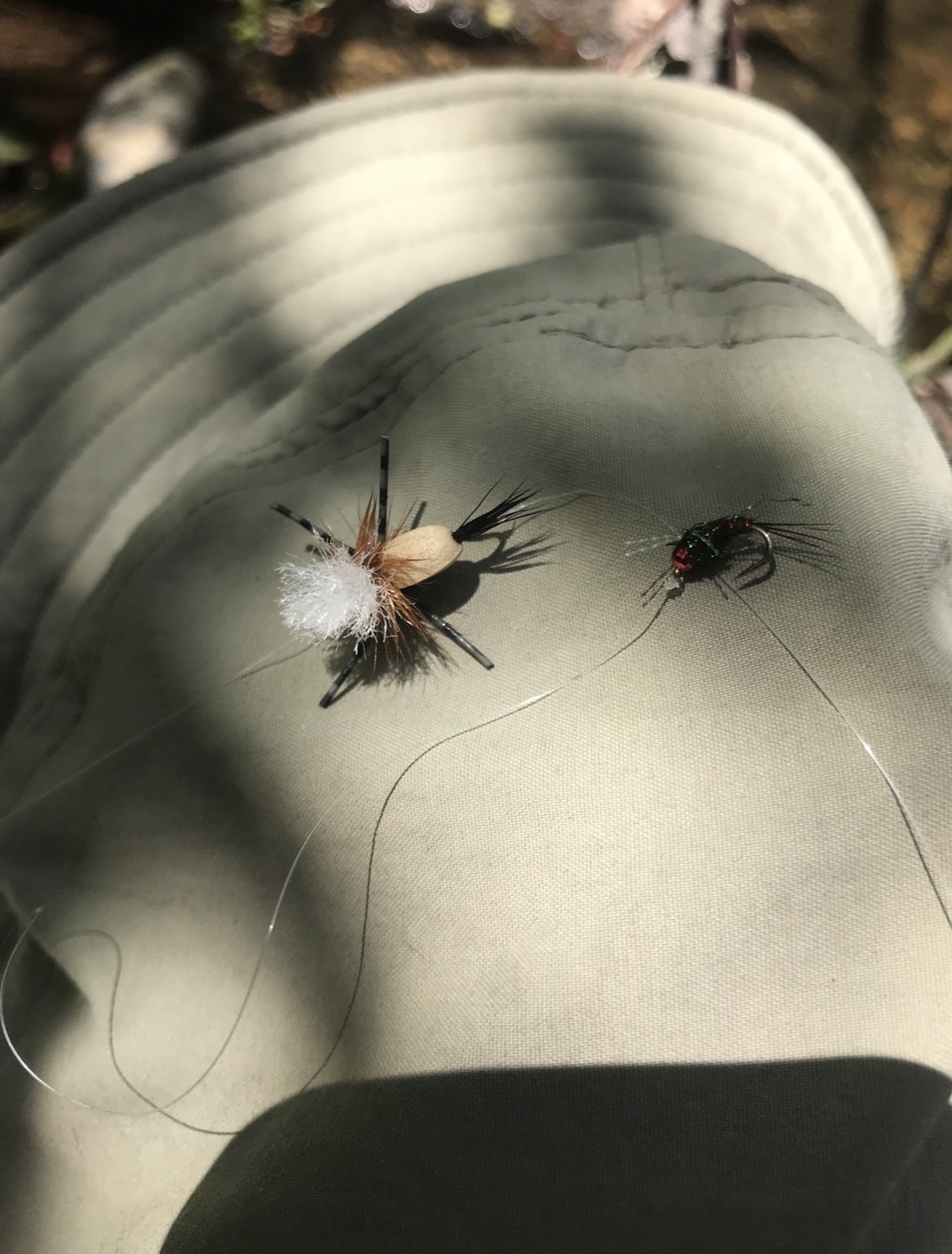 Dry fly and nymph resting on a hat brim