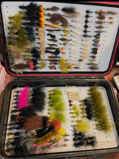 Large fly box filled with hand-tied trout flies, nymphs, and streamers